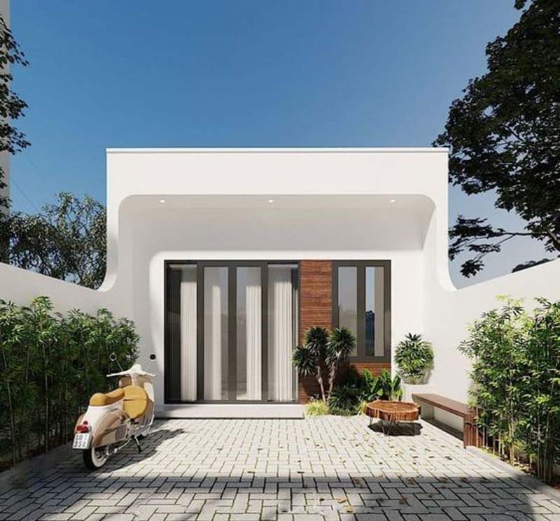 Nhà cấp 4 gọn gàng, hiện đại với sân rộng, được lót gạch, cây xanh và xe máy bên.