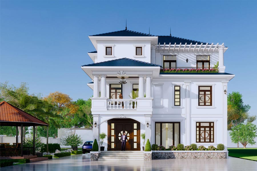 Biệt thự ba tầng hiện đại, mái xanh đen, phía trước là sân rộng thoáng đãng, cây xanh xung quanh và bầu trời trong xanh.