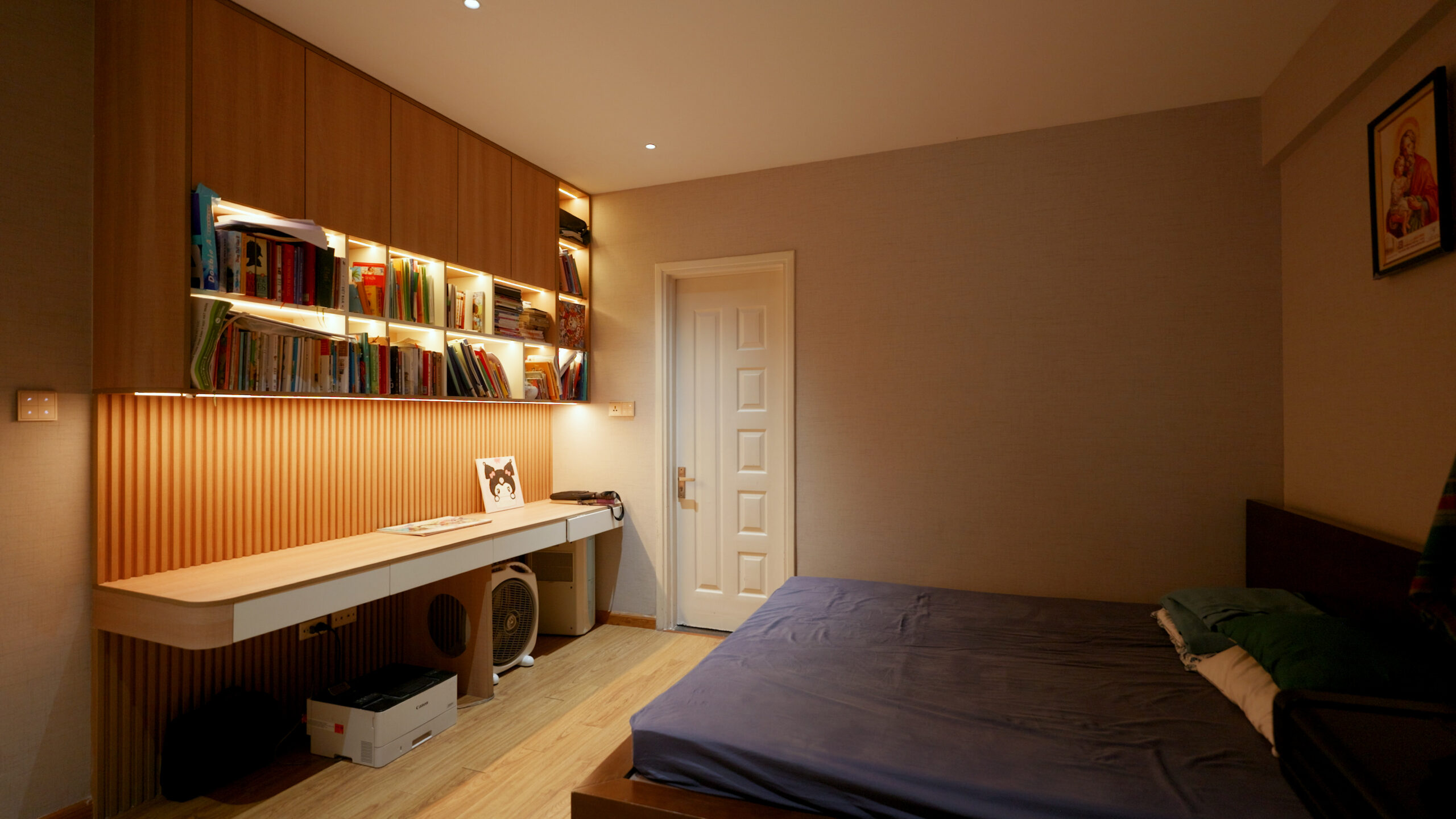 16-1-scaled-1 Phòng ngủ nhỏ gọn với giường đơn, bàn học có kệ sách, trang trí đèn và sàn gỗ ấm cúng.