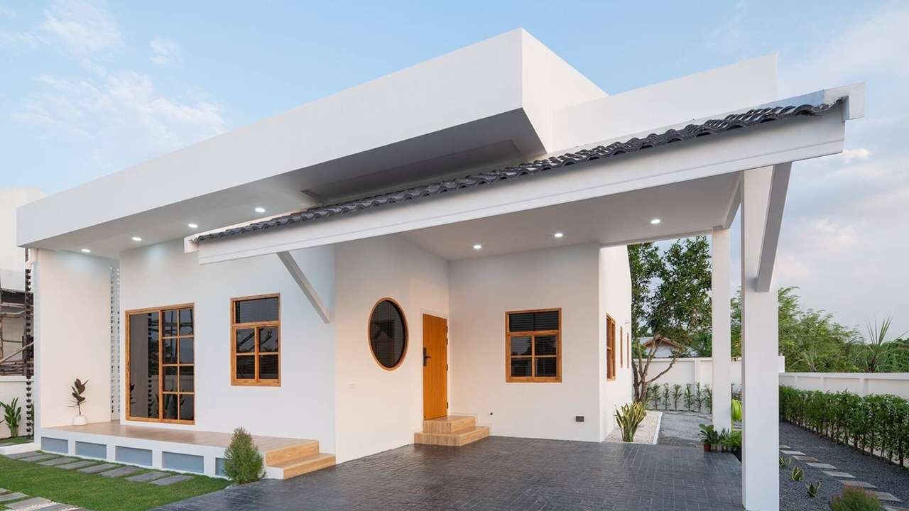 Ngôi nhà hiện đại một tầng, màu trắng, sân vườn rộng cùng cửa sổ kính.