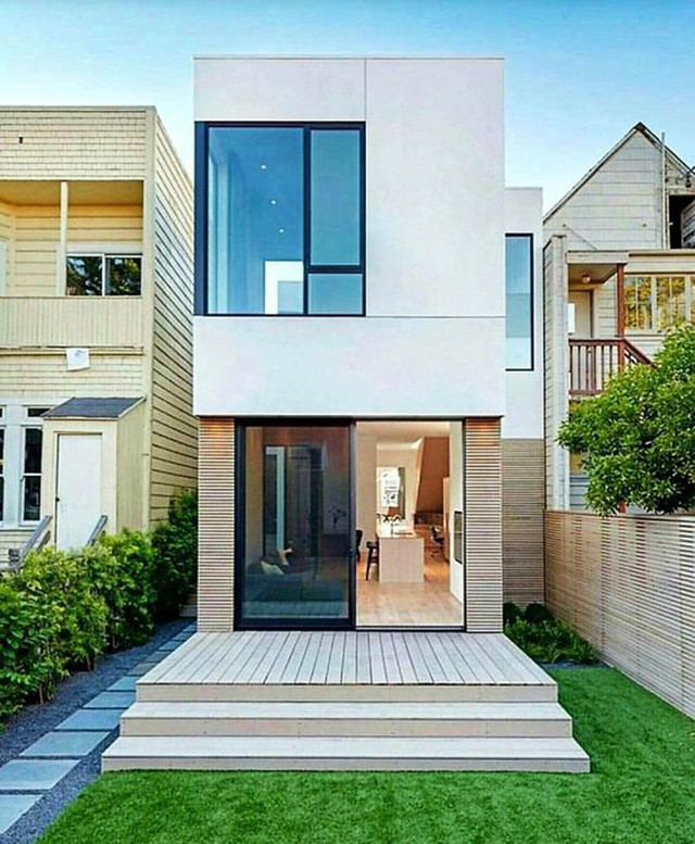 Ngôi nhà hiện đại sở hữu mặt tiền kính lớn và sân cỏ xanh, thiết kế hai tầng đơn giản và tinh tế.