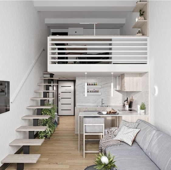 Căn hộ gác lửng hiện đại với nội thất tối giản, bao gồm bếp nhỏ, sofa và cầu thang dẫn lên tầng lửng.
