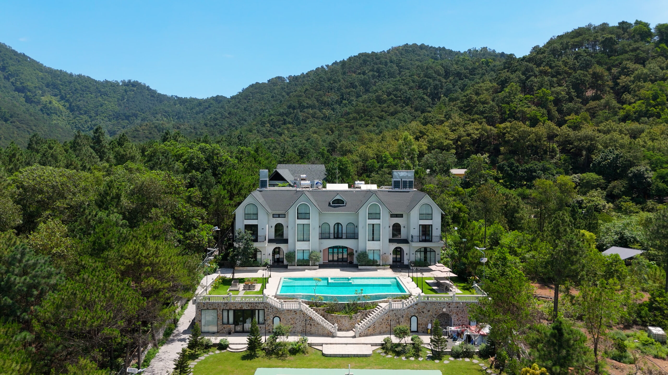 Biệt thự sang trọng với hồ bơi giữa thiên nhiên xanh tươi, bao quanh bởi rừng núi.