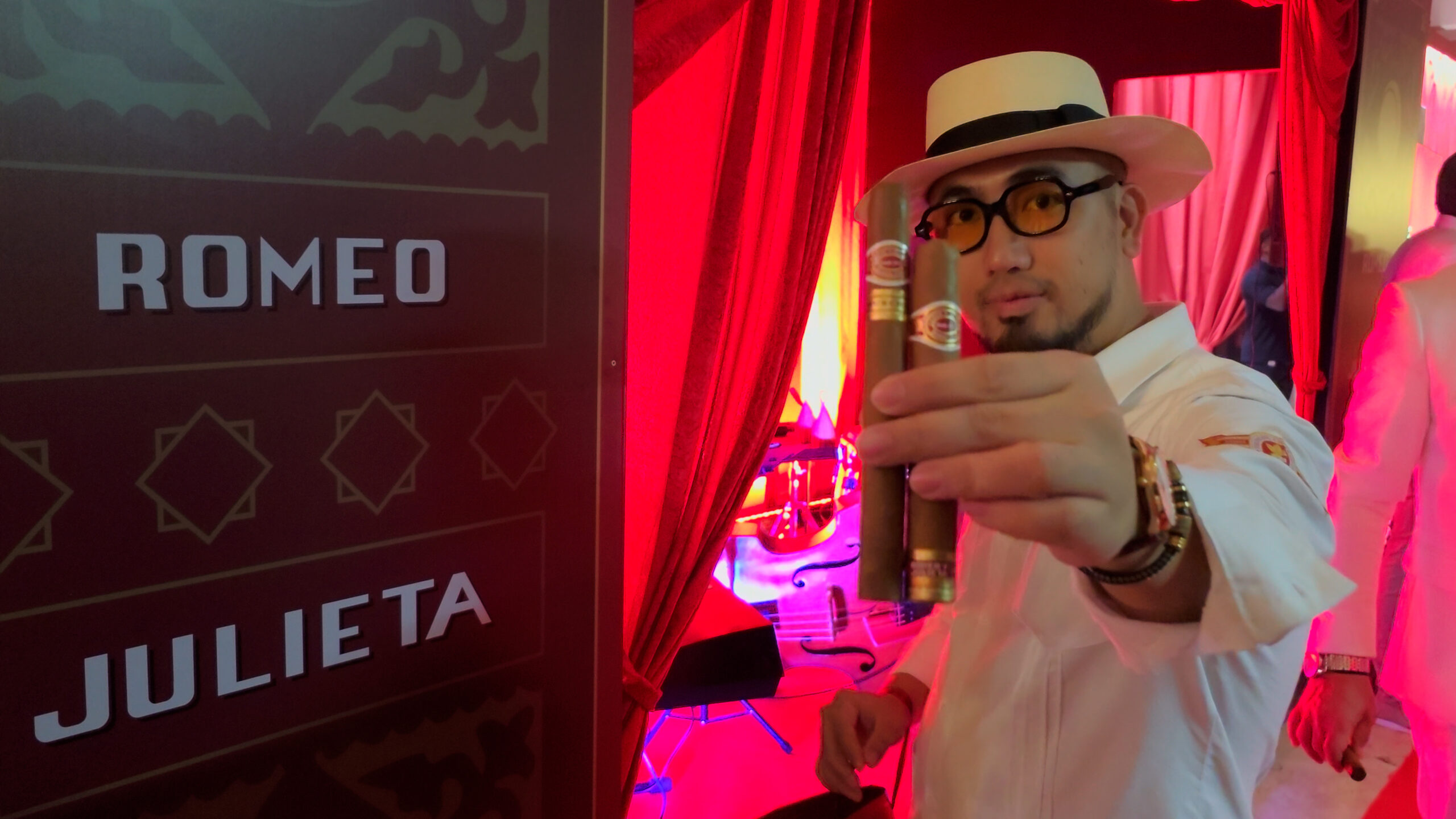 2-1-scaled-1 Người đàn ông cầm xì gà Romeo y Julieta trong không gian ánh sáng đỏ, nổi bật phong cách thời trang.