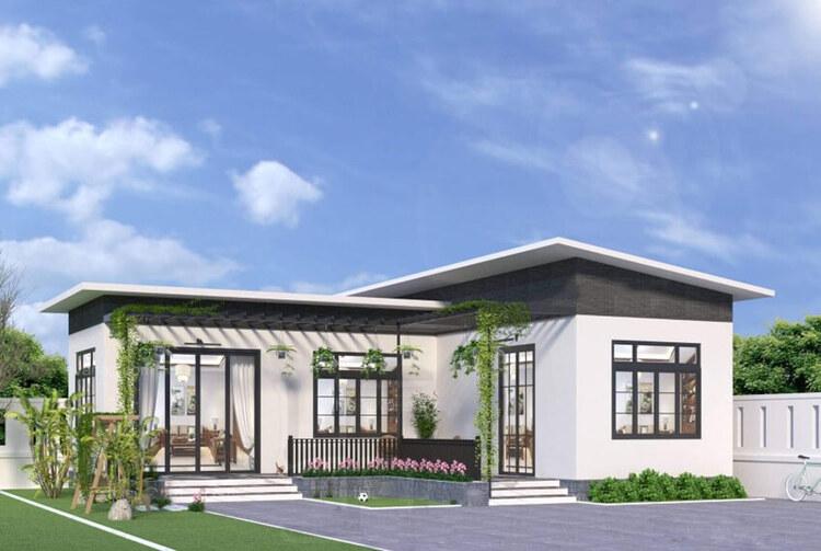 Nhà một tầng hiện đại với mái lệch, cửa kính lớn, và vườn nhỏ xanh mát phía trước, trời xanh có mây.