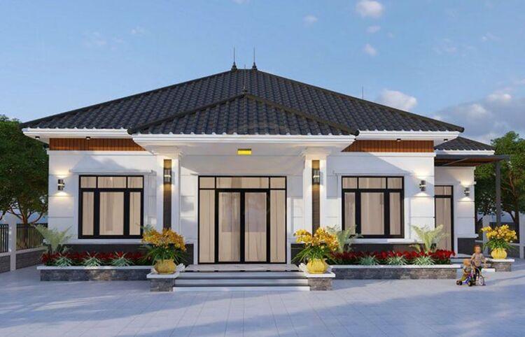 Ngôi nhà cấp 4 hiện đại với mái Thái, sân rộng được viền bởi cây cối dưới ánh nắng.