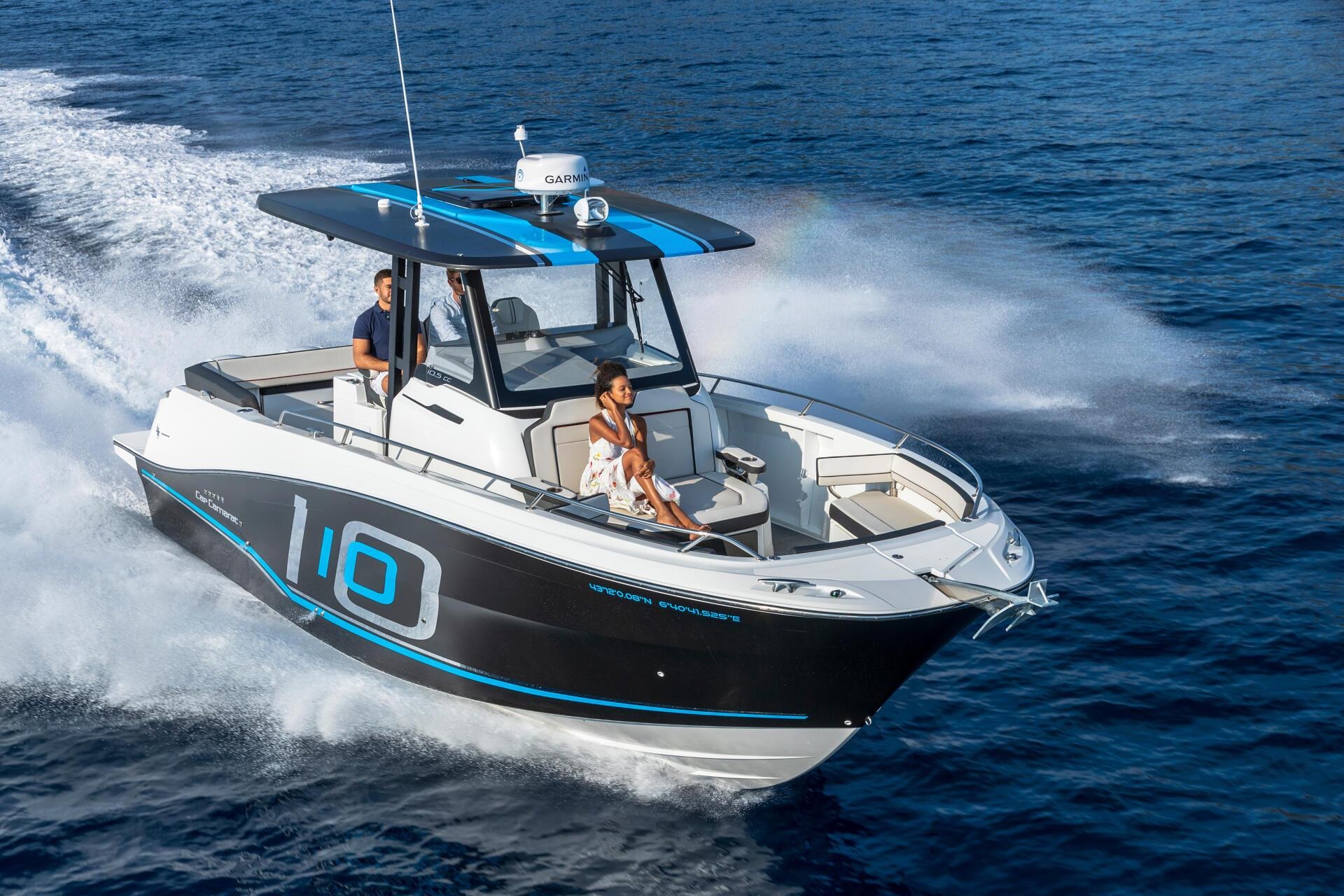 Dưới trời xanh, một chiếc thuyền máy cao tốc lướt sóng, chở theo ba người tận hưởng hành trình trên biển.