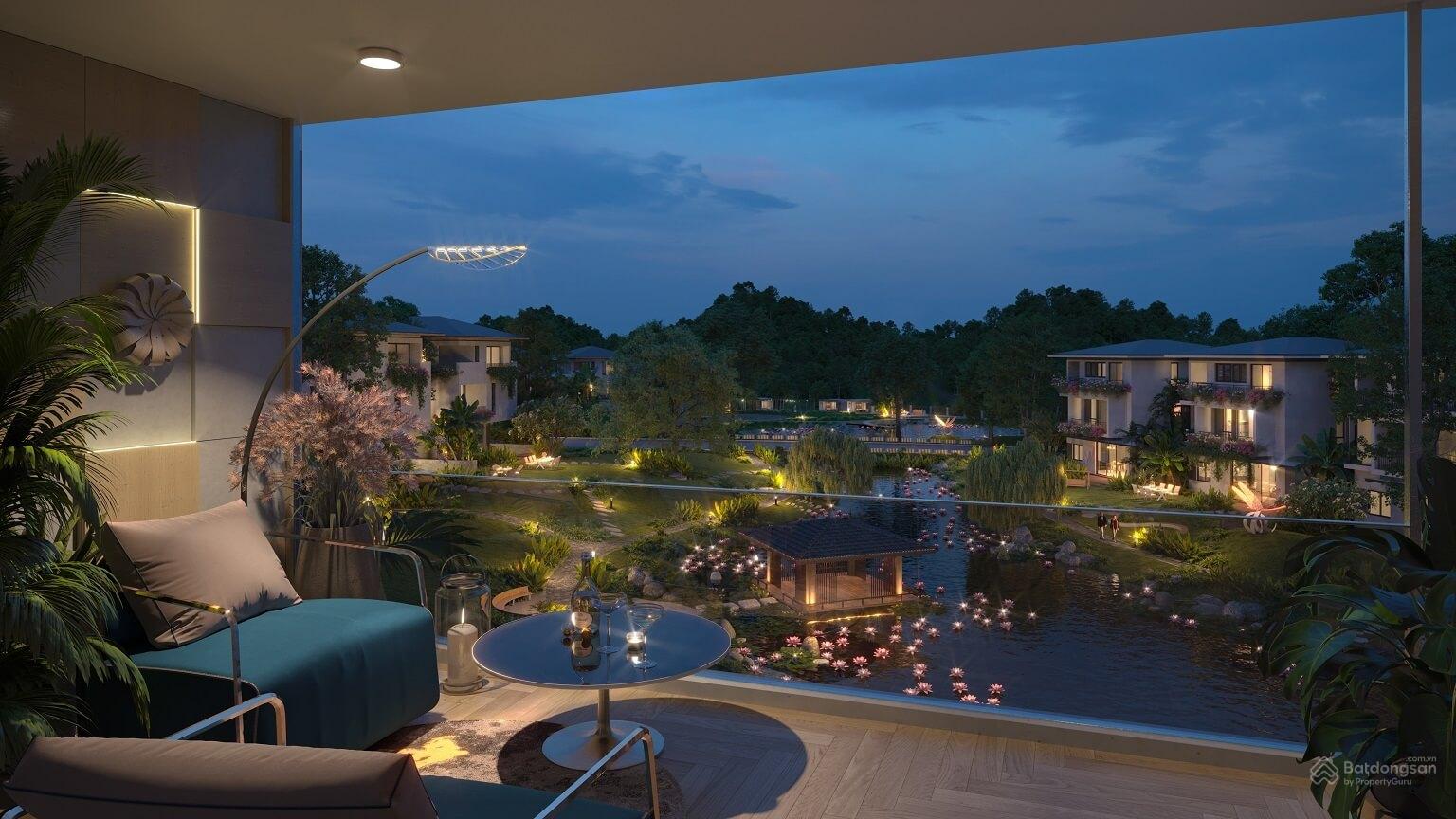 Ban công sang trọng nhìn ra khu vườn và hồ nước xanh mát buổi tối, ánh sáng dịu êm, không gian thư giãn lý tưởng.
