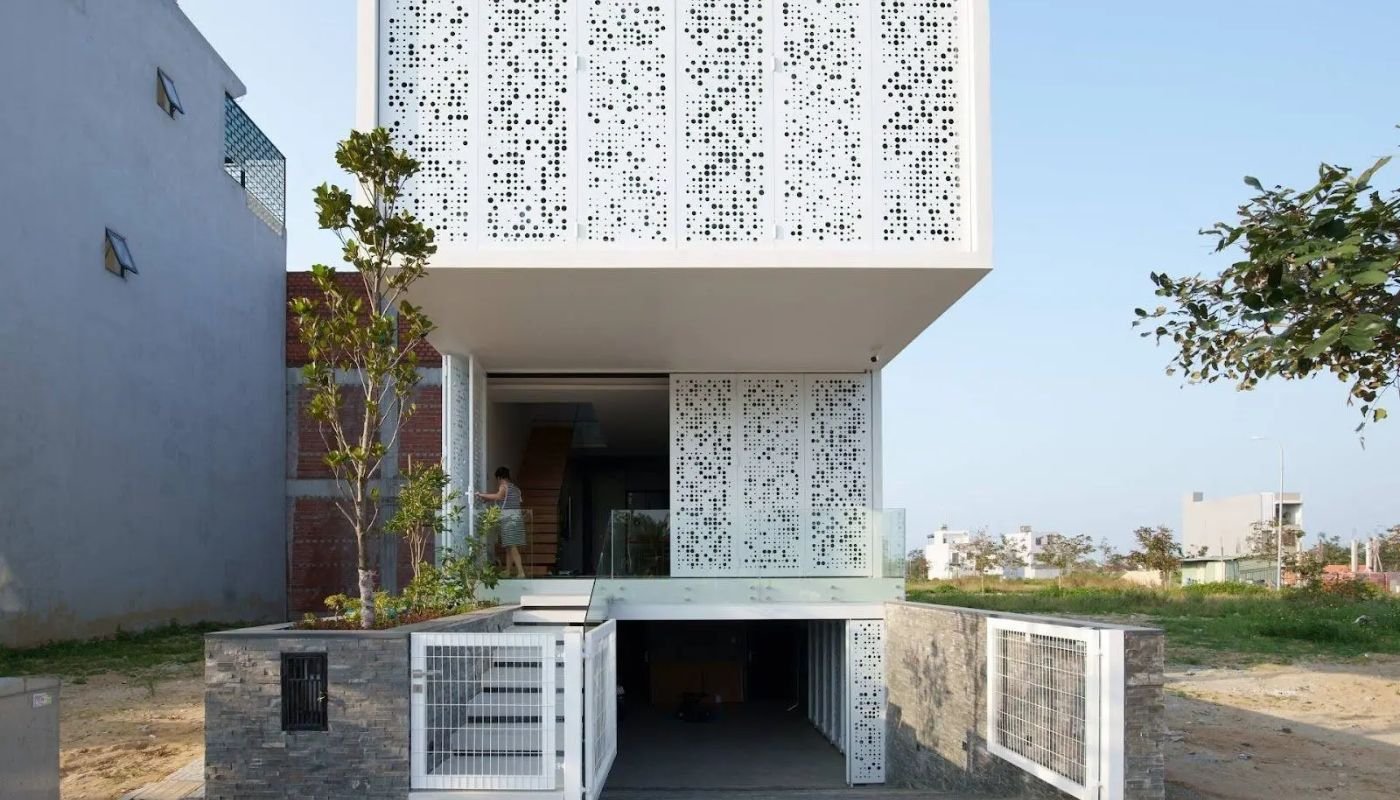 Ngôi nhà hiện đại với mặt tiền lỗ thoáng, khu vườn nhỏ phía trước, khung cảnh xung quanh thoáng đãng.