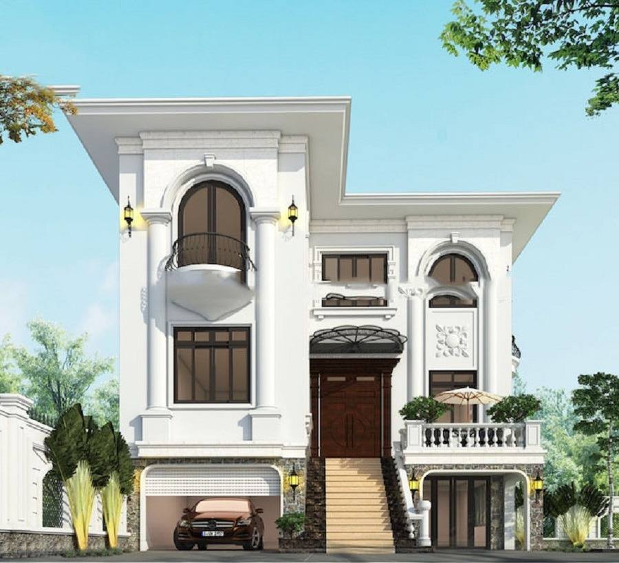 Ngôi biệt thự hai tầng sang trọng màu trắng, có ban công và gara, nằm giữa cây xanh tươi tốt.