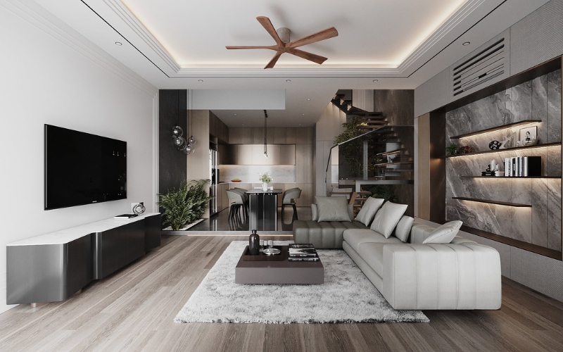 Phòng khách hiện đại với sofa trắng, bàn cà phê, quạt trần gỗ và bếp mở, trang trí tường tối màu.