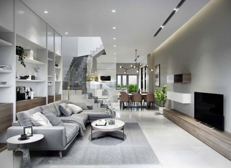 Phòng khách hiện đại với sofa xám, bàn tròn, kệ trưng bày và lối cầu thang dẫn lên tầng trên, kèm khu vực ăn tối.