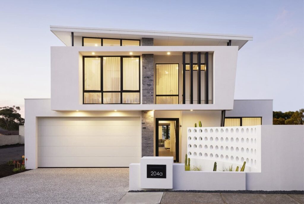 Nhà hiện đại hai tầng với cửa sổ lớn và tường chắn tạo kiểu trang trí, ánh sáng buổi tối.