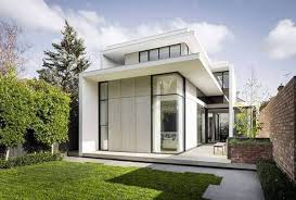 Nhà hiện đại với thiết kế minimal, cửa kính lớn, sân vườn xanh mát bao quanh.