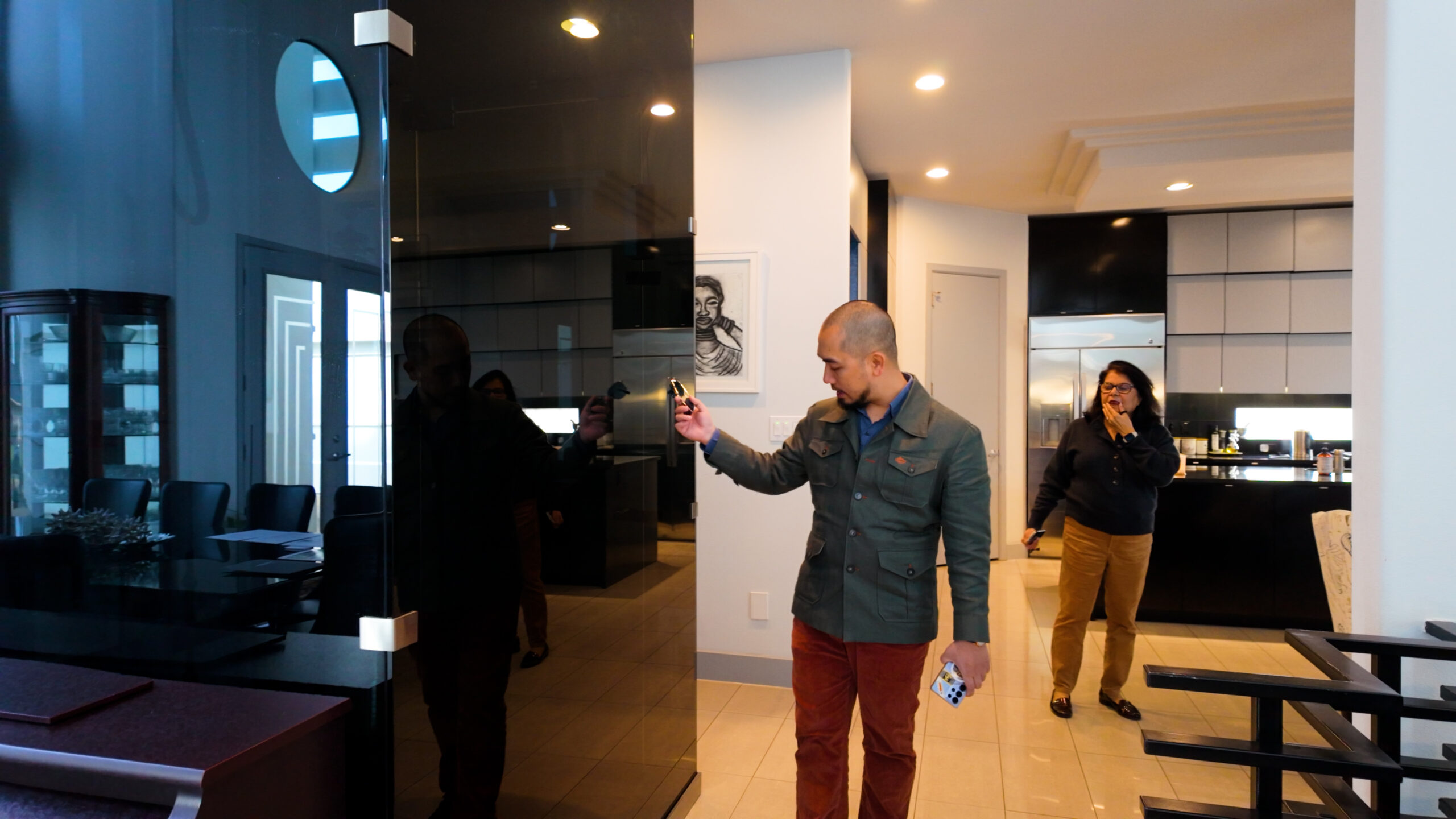 4-3-scaled-1 Người đàn ông mở cửa kính trong văn phòng, người phụ nữ đứng gần bếp cười nói.