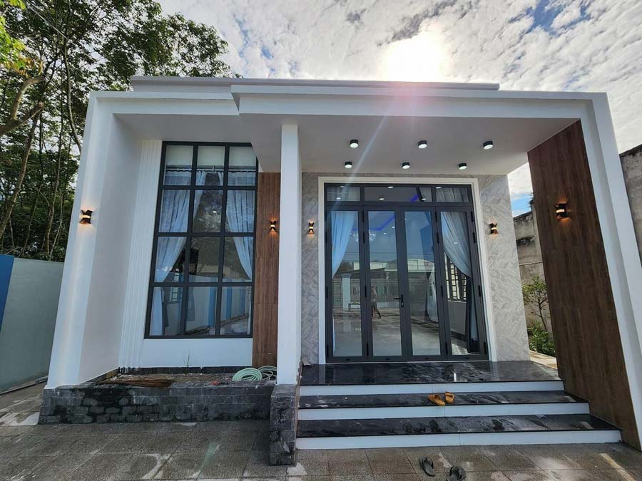 4-9-1 Ngôi nhà một tầng hiện đại với mặt kính lớn và ánh sáng trang trí, bầu trời xanh ngát.