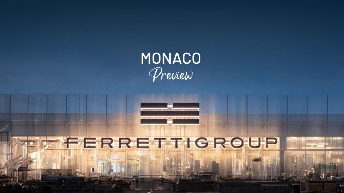 Tòa nhà Ferretti Group ban đêm với chữ MONACO Preview phía trên, ánh sáng lung linh, nền trời tối.