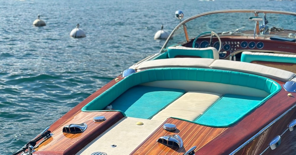 Thuyền buồm sang trọng trên biển xanh, với nội thất gỗ và ghế da màu xanh dương.