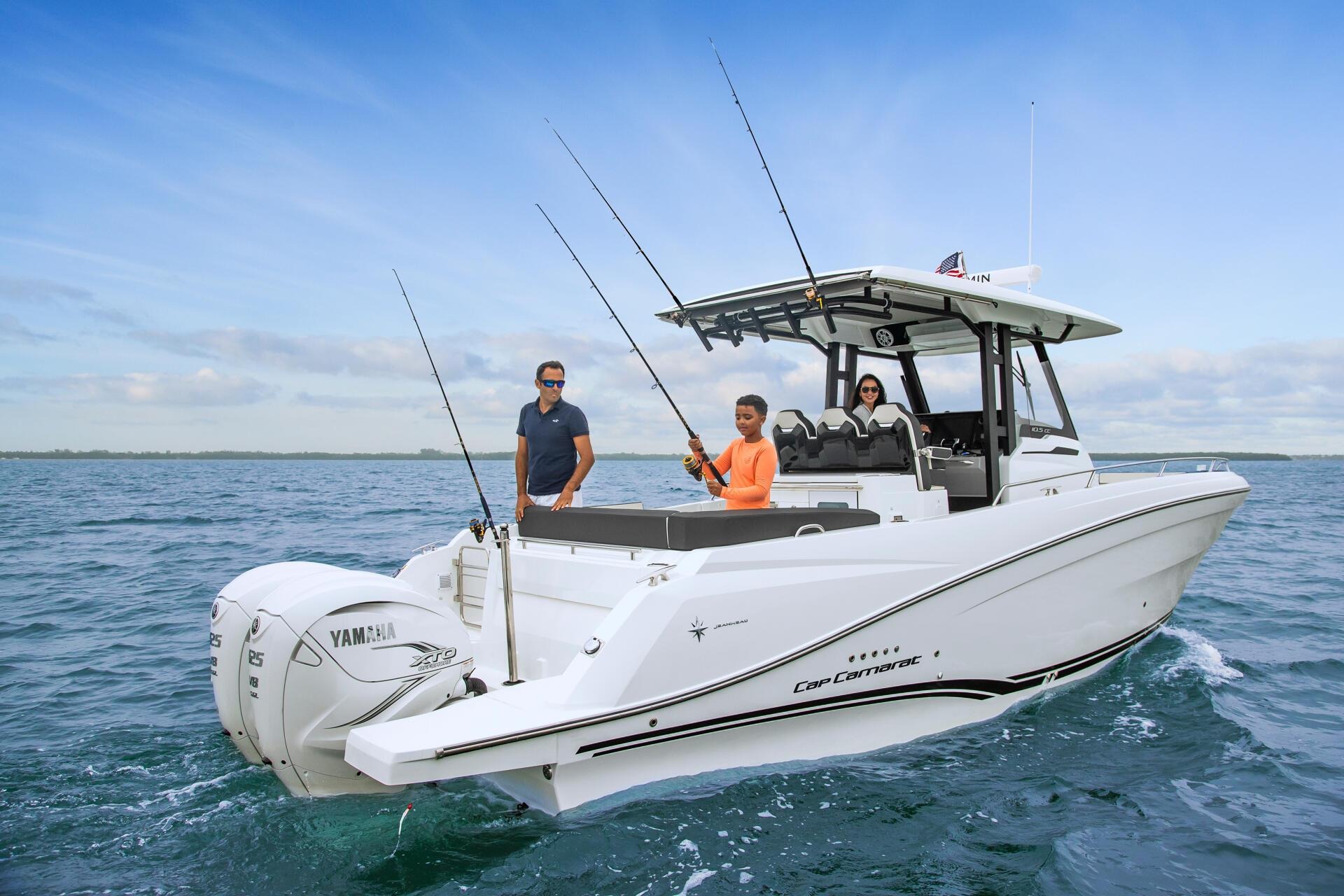 Ba người câu cá trên thuyền Cap Camarat ngoài biển xanh, một người cầm cần câu, thời tiết nắng đẹp.