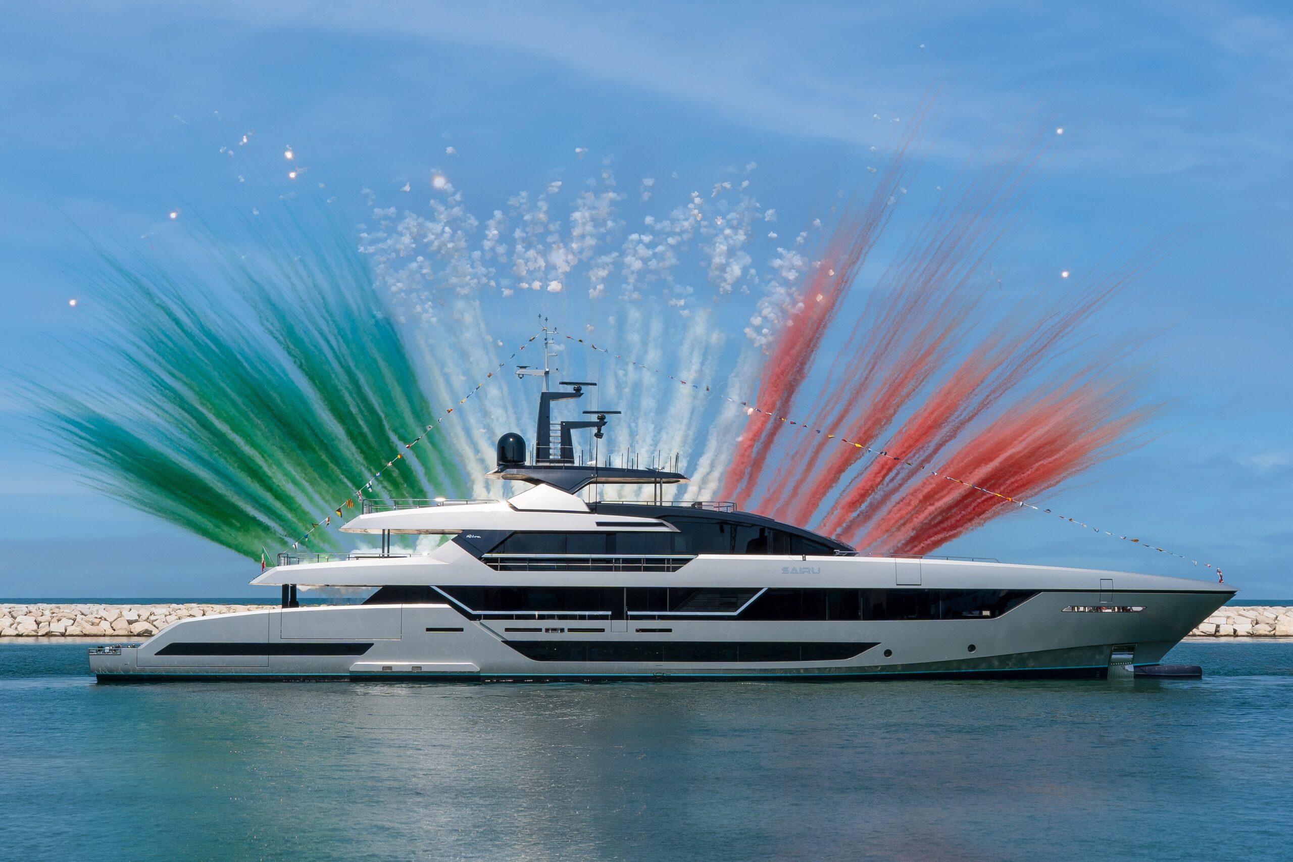 Du thuyền sang trọng bên pháo hoa màu xanh, trắng, đỏ trên nền trời xanh.