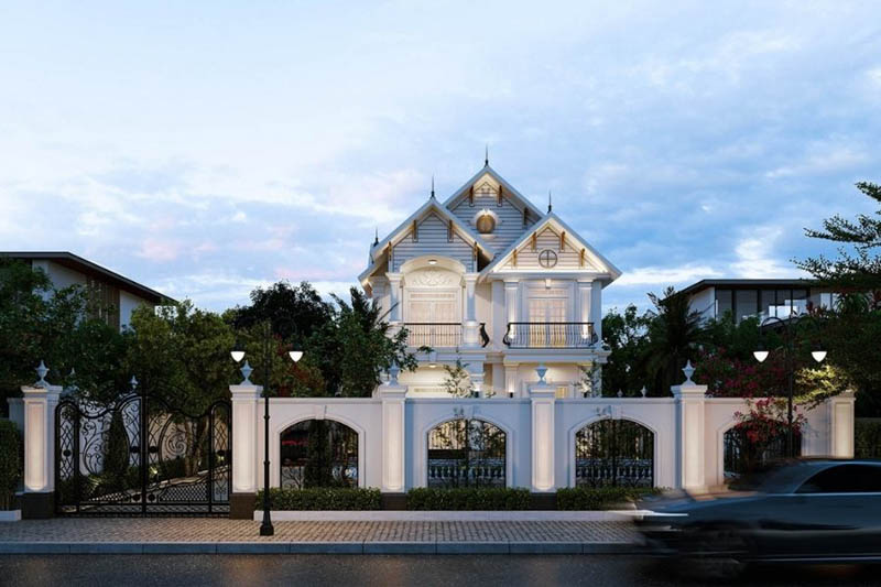 Biệt thự xa hoa phong cách cổ điển với hàng rào trắng, vườn cây xanh và bầu trời xanh.