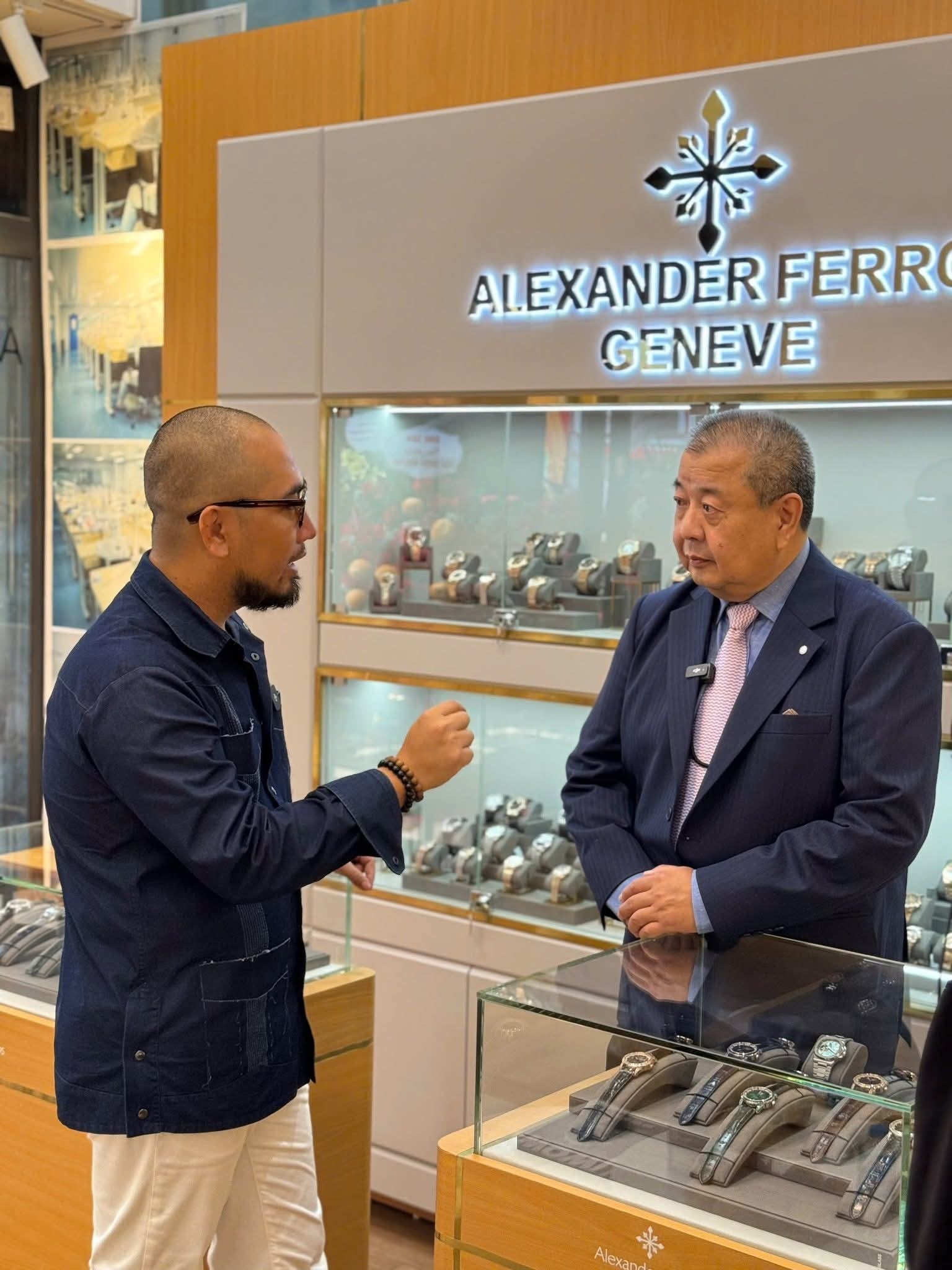 Hai người đàn ông thảo luận trong cửa hàng đồng hồ Alexander Ferro Geneve.