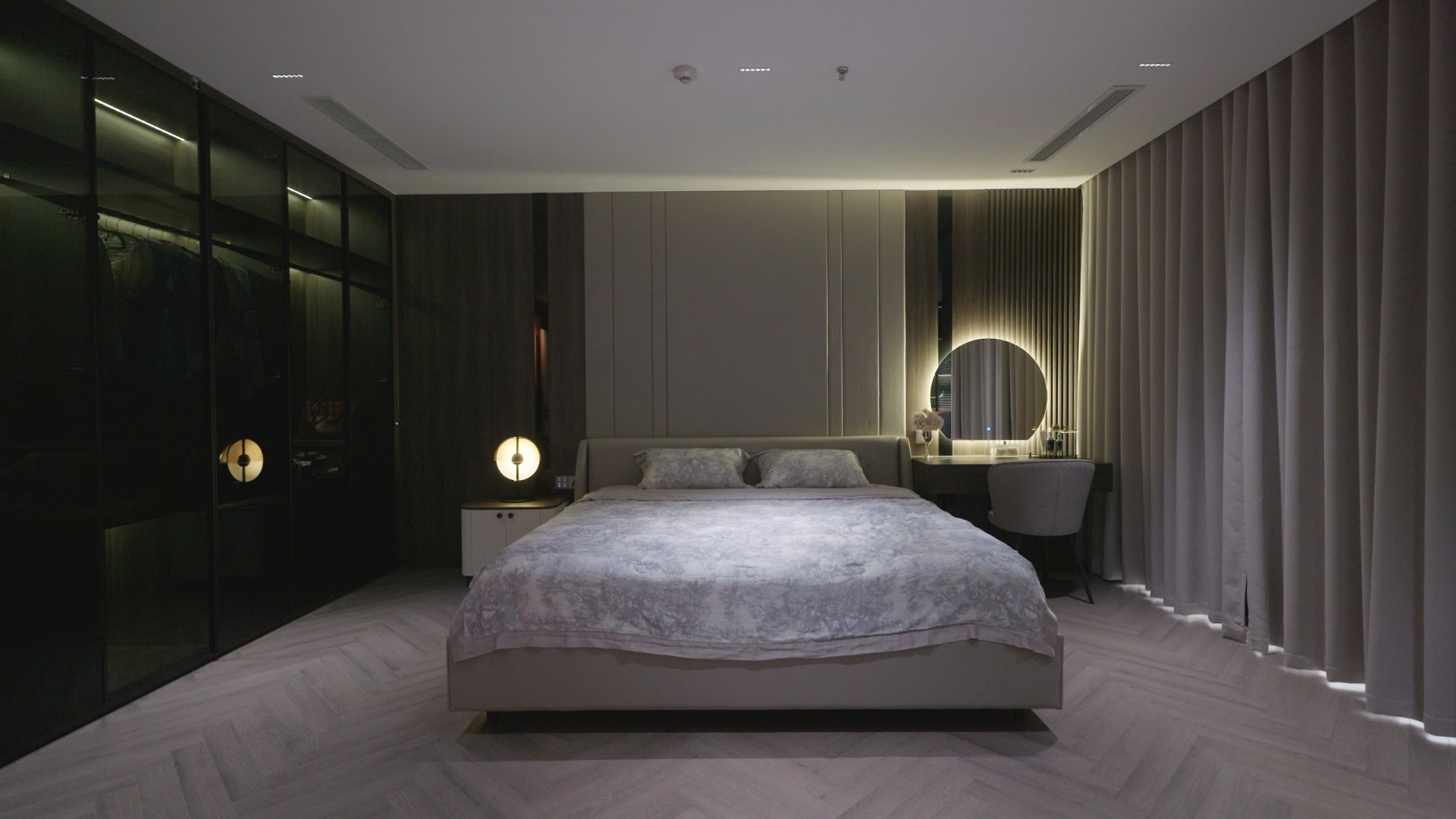 5w0kyj72x3sfliuot8h1 Phòng ngủ hiện đại với giường lớn, ánh sáng dịu và bàn trang điểm có gương tròn phát sáng.