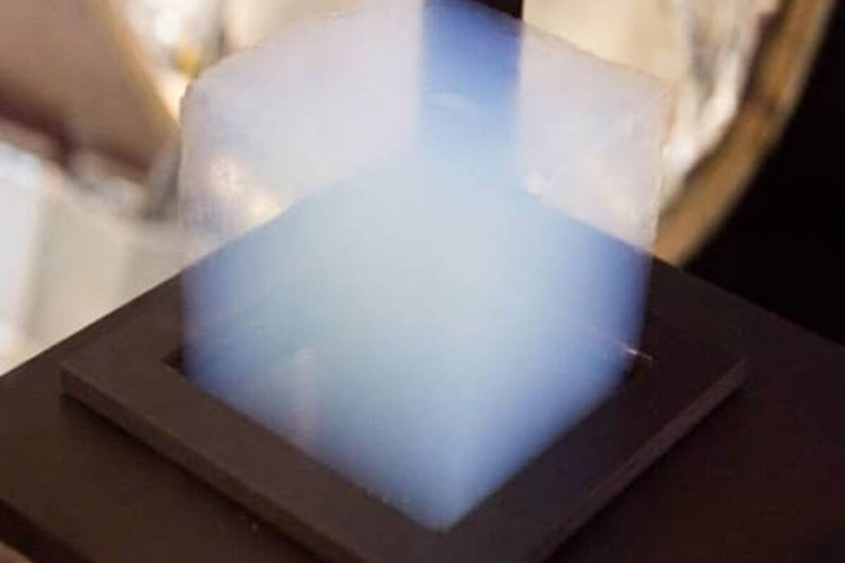 7y0rt2j5xh9bkpn6g3ai Khối aerogel nhẹ trên nền đen, ánh sáng xanh mờ ảo, chất liệu cách nhiệt ưu việt.