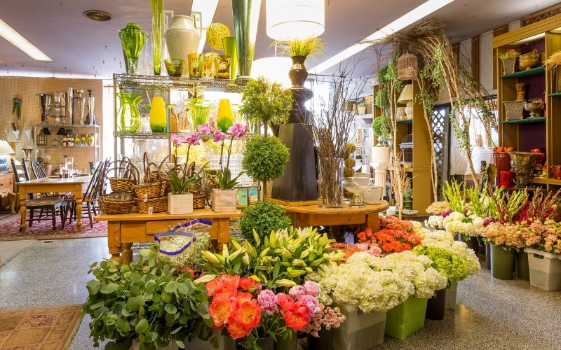 Cửa hàng hoa tươi bày bán đa dạng cây cảnh, bình hoa và phụ kiện trang trí.