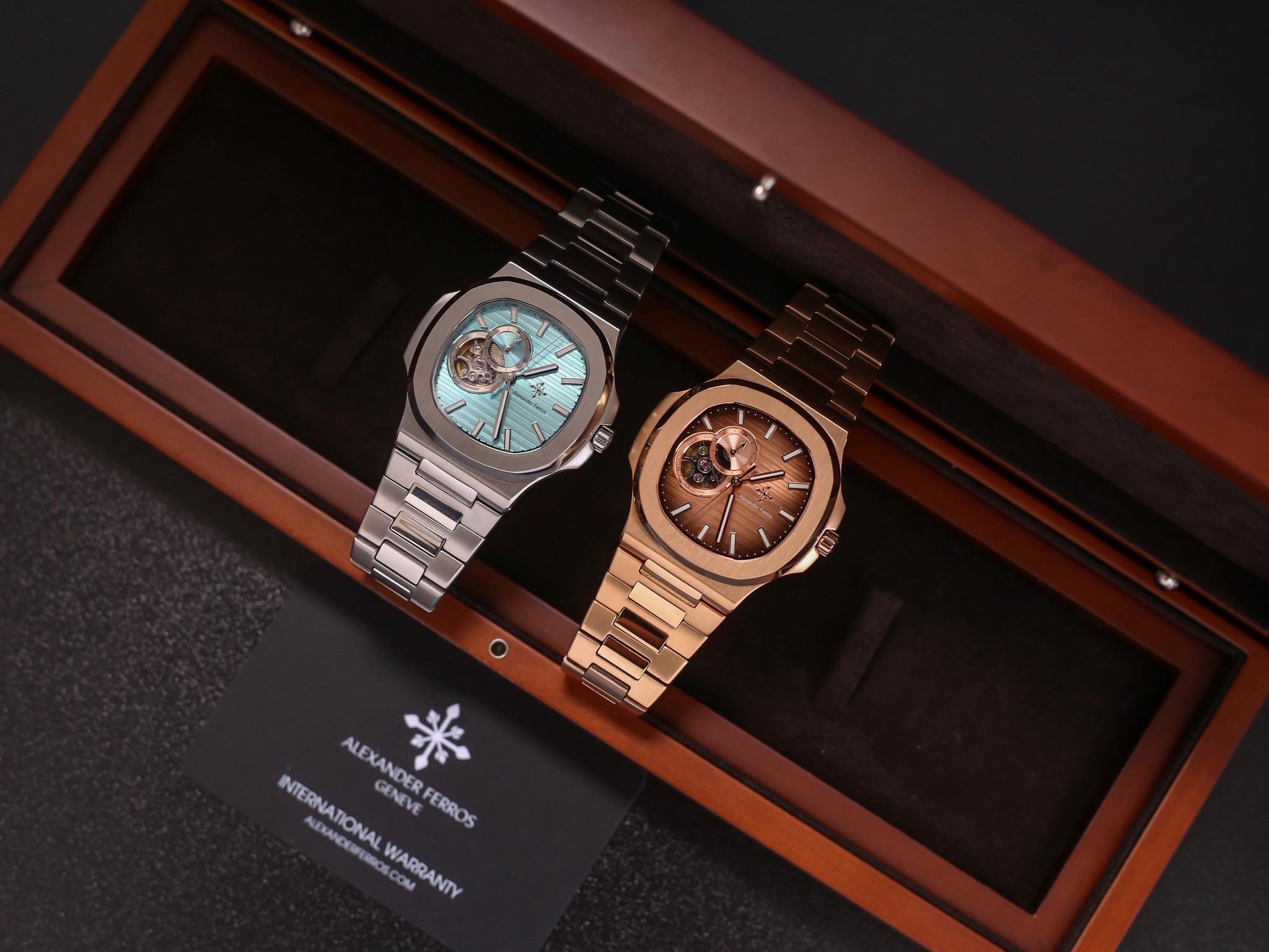 Hai chiếc đồng hồ kim loại cao cấp trong hộp gỗ, mặt số lộ cơ tinh tế.