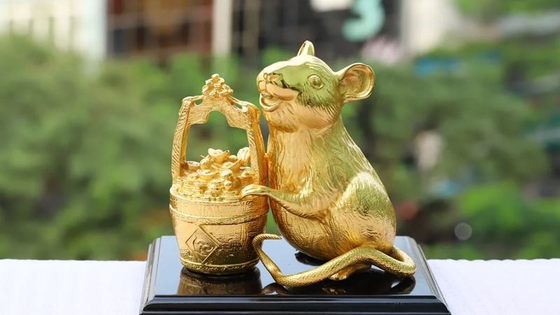 Tượng chuột vàng cầm thùng tiền vàng, biểu tượng tài lộc và thịnh vượng trên nền xanh, phong cách trang trí nhà cửa.