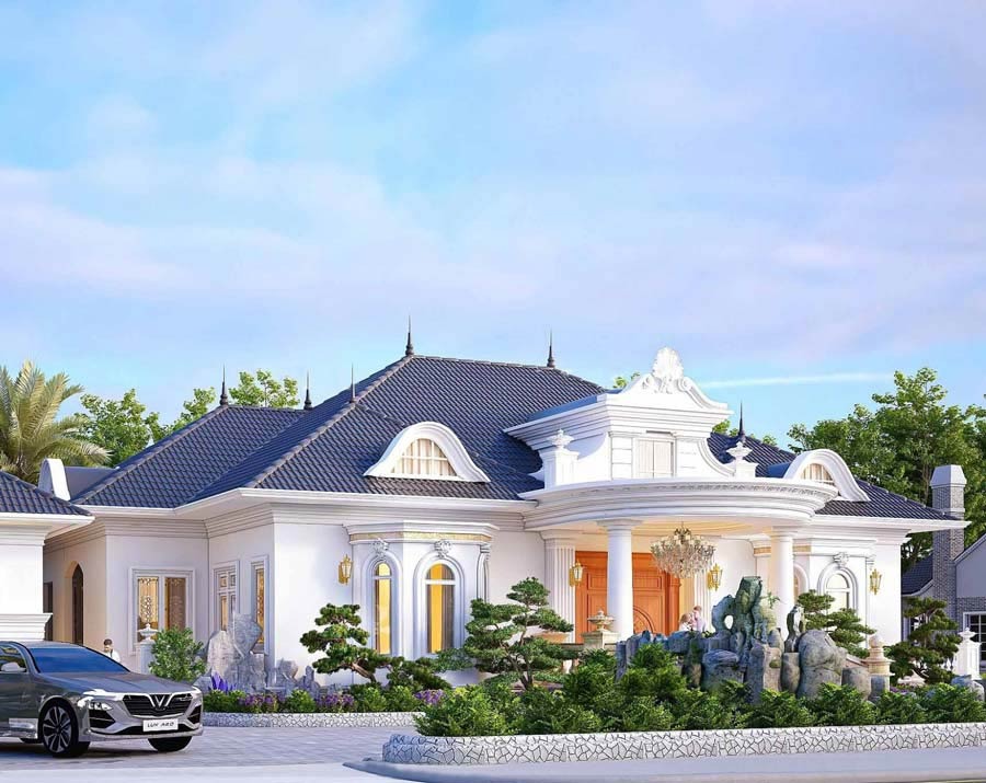 Biệt thự sang trọng với mái ngói xanh, vườn cây cảnh, và ô tô đỗ trước nhà dưới bầu trời xanh.