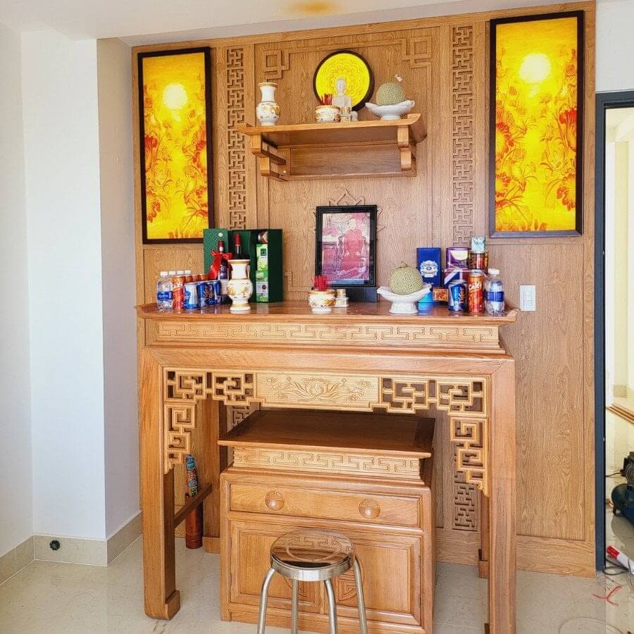 Bàn thờ gỗ trang trí với đồ thờ cúng và tranh ảnh, phong cách truyền thống Việt Nam.