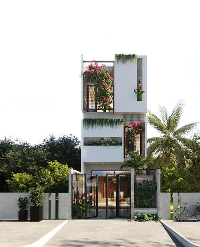 Ngôi nhà phố hiện đại với cây xanh và hoa trang trí trên ban công, tạo không gian sống xanh và thoáng đãng.