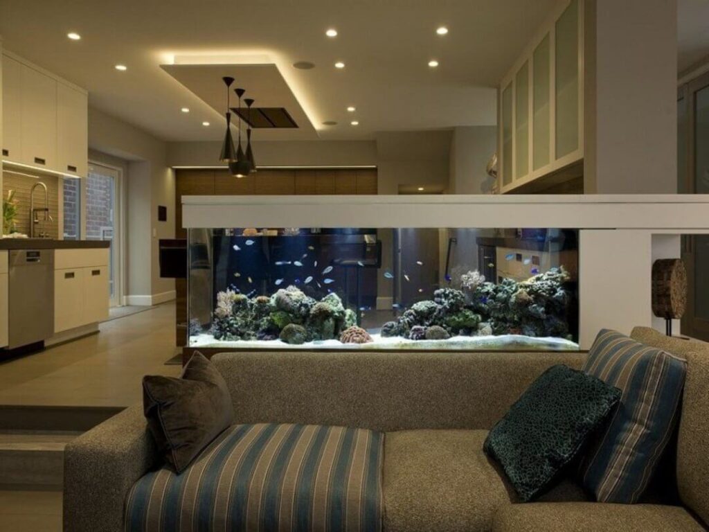 Phong khách hiện đại với hồ cá lớn trang trí, sofa thoải mái và ánh sáng ấm áp.