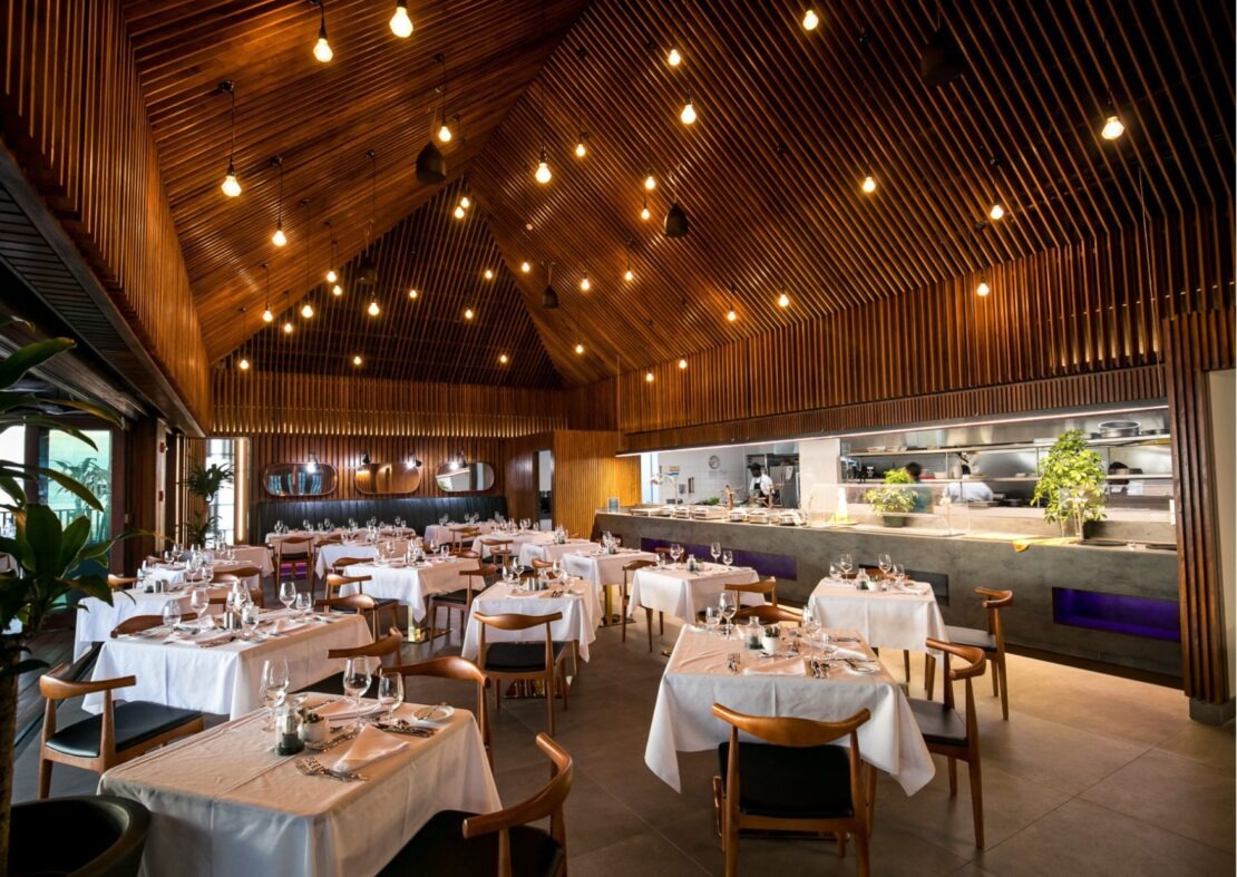 beaches-st-barths-1-1110x787-1 Nhà hàng sang trọng với trần gỗ, ánh đèn ấm áp và bàn ăn được bày trí lịch lãm, tạo không gian ấm cúng.