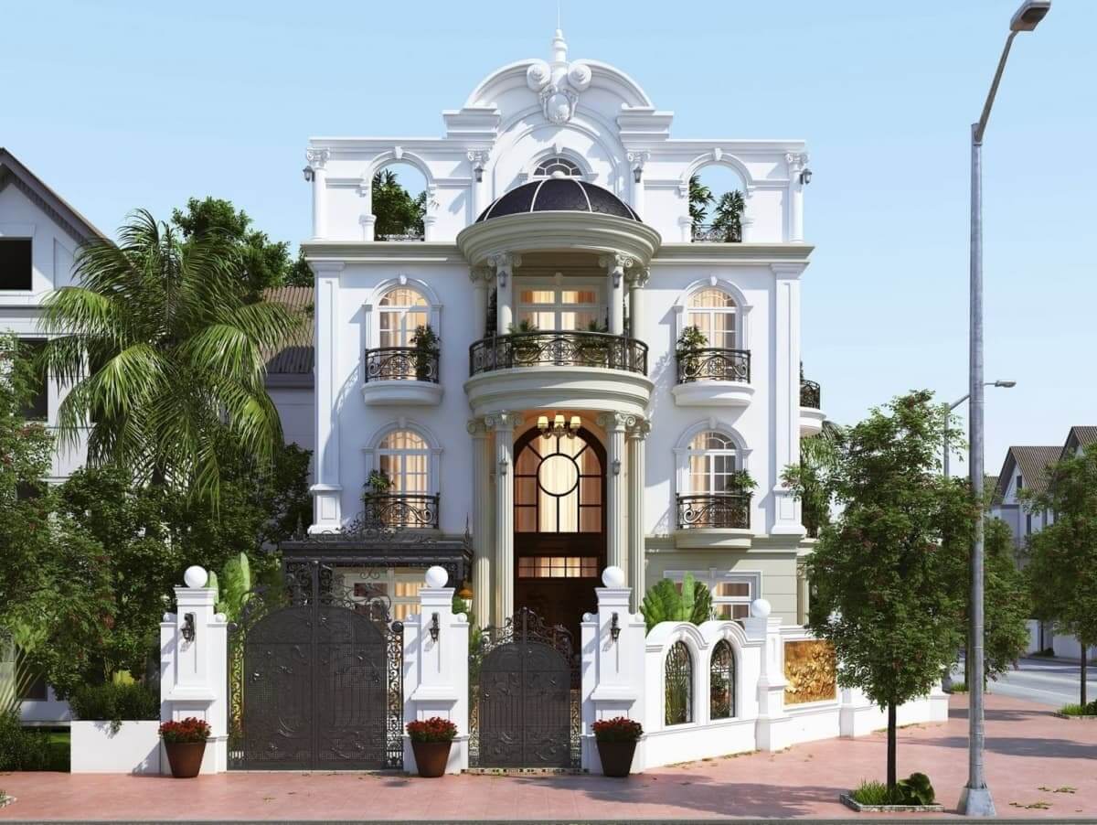 Biệt thự tân cổ điển trắng với ban công sắt, cây xanh xung quanh, kiểu dáng sang trọng giữa khu phố.