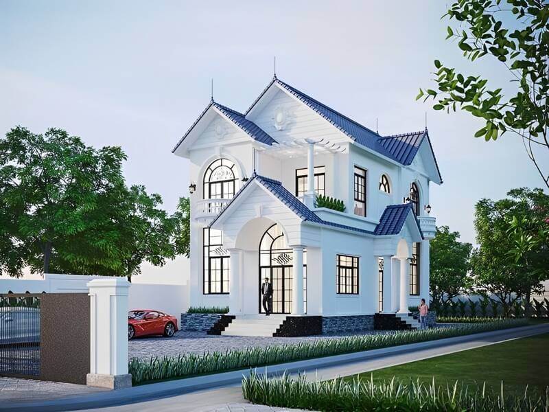 Nhà 2 tầng mái thái màu trắng, kiến trúc hiện đại, bao quanh cây xanh và đường đi rộng rãi.