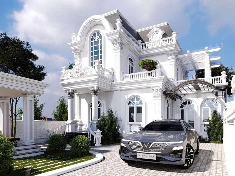 Biệt thự phong cách tân cổ điển màu trắng với xe hơi hiện đại phía trước, cây xanh xung quanh.