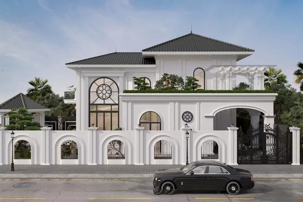 Biệt thự sang trọng với mái ngói đen, tường trắng và ô tô đen đậu phía trước.