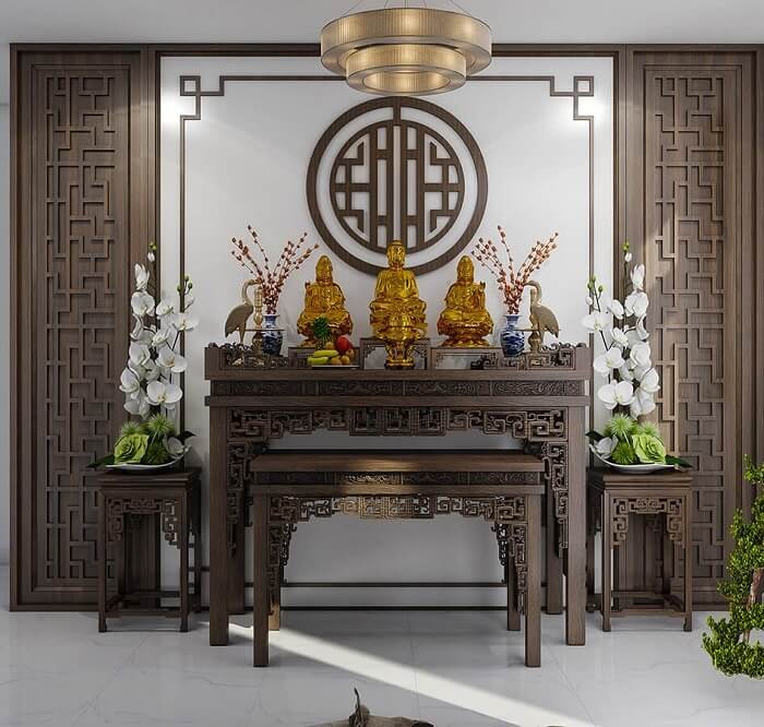 Bàn thờ gia tiên gỗ chạm khắc tinh xảo, với tượng Phật và hoa trang trí, không gian trang nghiêm thanh tịnh.