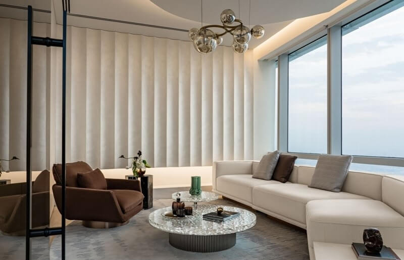 bo-sofa-tiep-khach Phòng khách sang trọng với ghế sofa trắng, cửa sổ lớn và đèn chùm hiện đại.