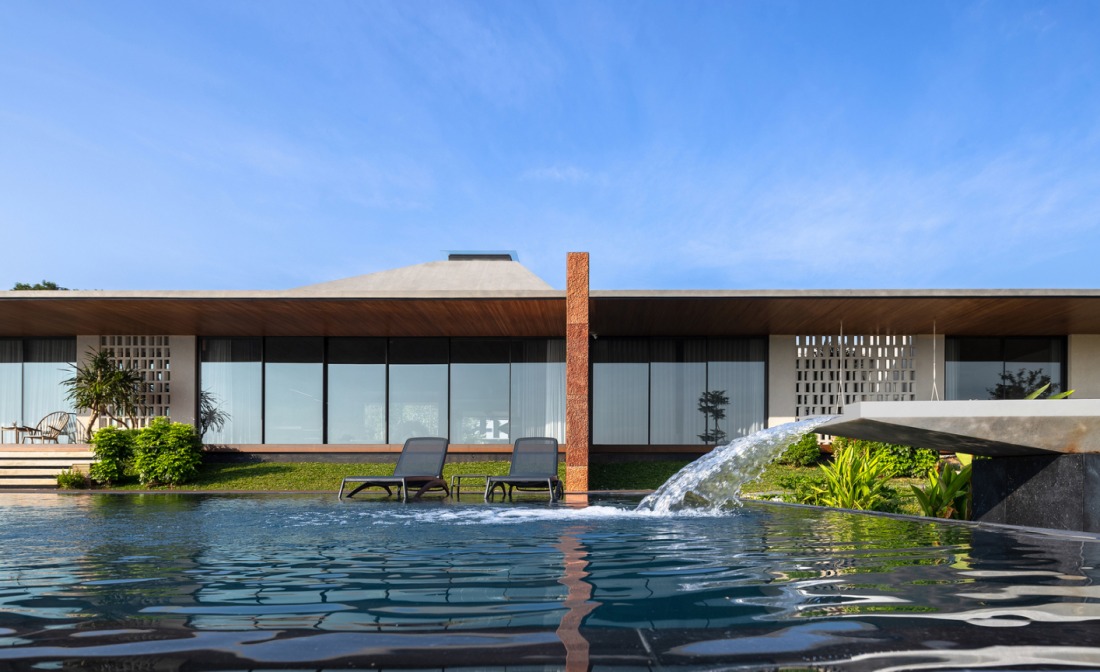 bv4 Biệt thự hiện đại với hồ bơi và ghế nằm ngoài trời dưới bầu trời xanh.