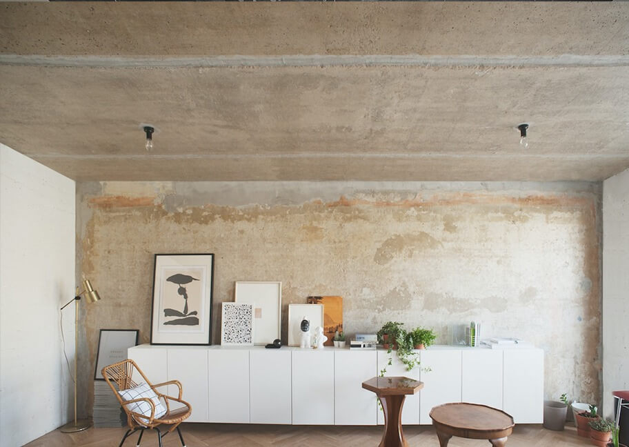 Phòng khách phong cách công nghiệp, nội thất tối giản với tủ trắng, tranh nghệ thuật và cây xanh trang trí.