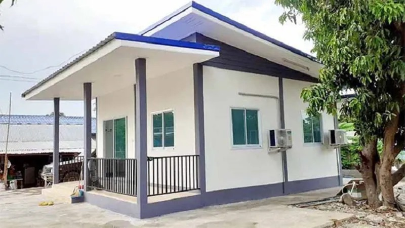 Nhà cấp 4 mái lệch hiện đại với sân rộng và cây xanh ở bên cạnh.