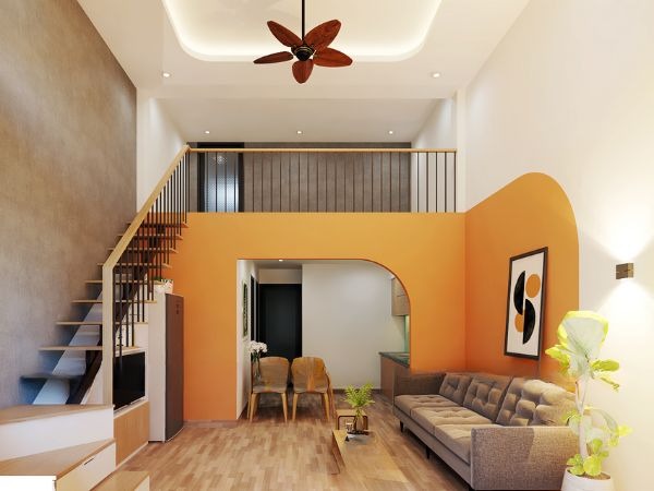 Phòng khách hiện đại với trần nhà cao, quạt trần, sofa xám, tường cam và cây xanh trang trí.