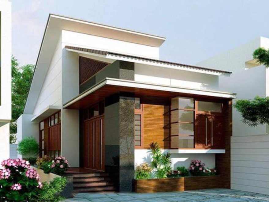 cac-yeu-to-tac-dong-den-chi-phi-xay-nha-1-tang-100m2-2 Nhà cấp 4 hiện đại với mái lệch, thiết kế tông màu trắng và nâu, nhiều cửa kính và cây xanh trang trí.