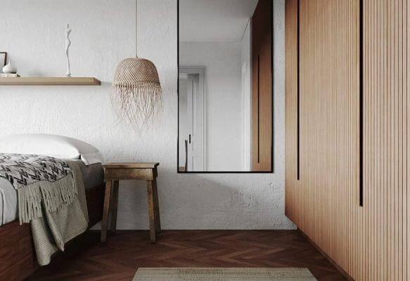 Phòng ngủ hiện đại với nội thất gỗ, giường, đèn trang trí và tấm gương lớn.