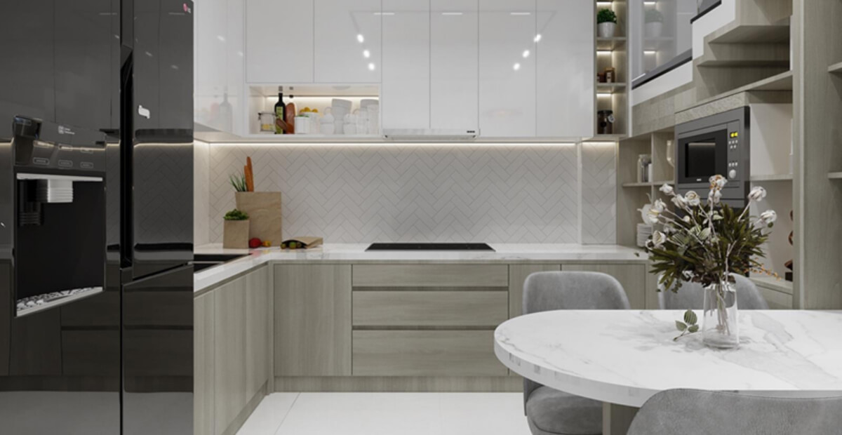 Nhà bếp hiện đại với tủ trắng, bàn đá hoa cương, tủ lạnh đen, và bình hoa trên bàn ăn.