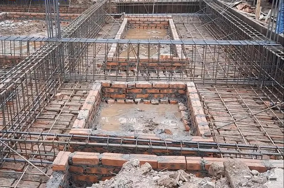 Móng nhà bê tông sắt thép với cấu trúc gạch, chuẩn bị xây dựng, đảm bảo nền móng vững chắc.